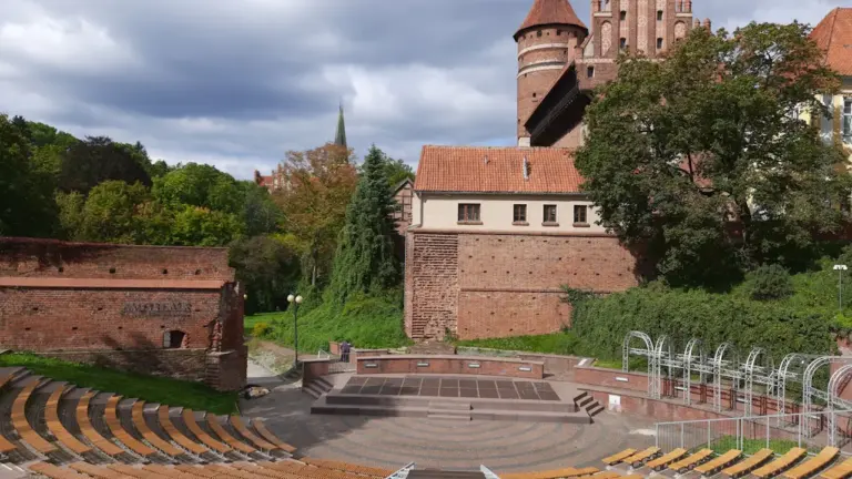 Amfiteatr nad Ukielem z zamkiem w tle w słoneczny jesienny dzień w Olsztynie