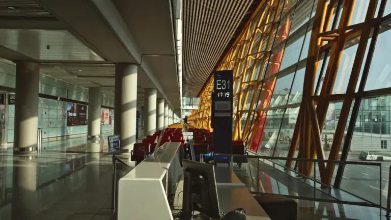 Nowoczesny terminal lotniczy z pustą poczekalnią i dużymi oknami w słoneczny dzień.