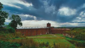 Historyczny budynek Twierdzy Modlin pod dramatycznym, pochmurnym niebem we wrześniowy dzień.