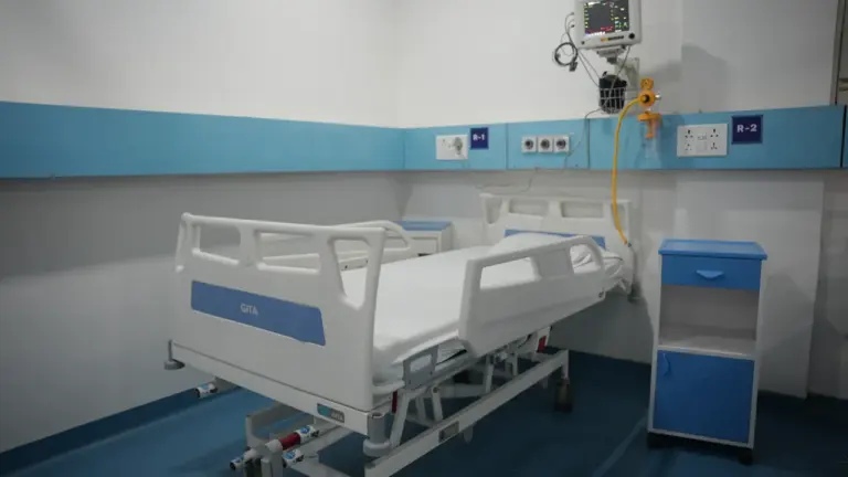 Nowoczesna sala szpitalna z łóżkiem medycznym oraz specjalistycznym sprzętem do monitorowania pacjenta.