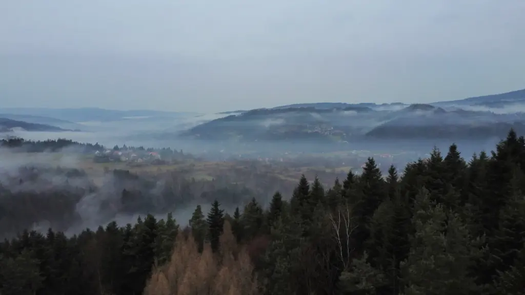 Jesienny poranek z mgłą nad doliną i zabudowaniami w Polsce